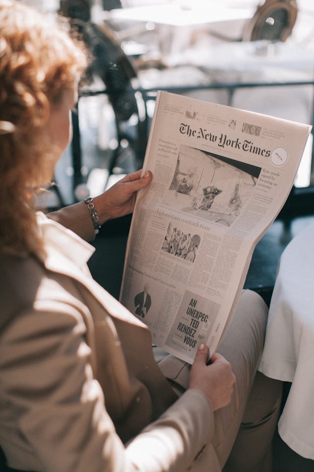 Mujer leyendo el periódico.