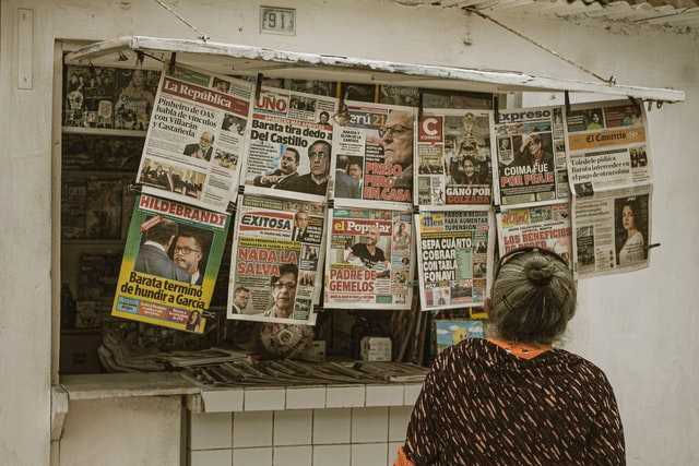 Una dona mirant diaris al carrer